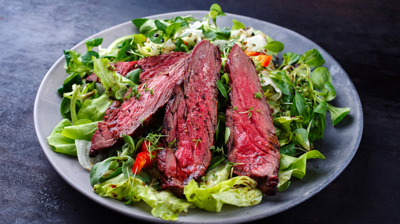 Skirt steak on top of salad