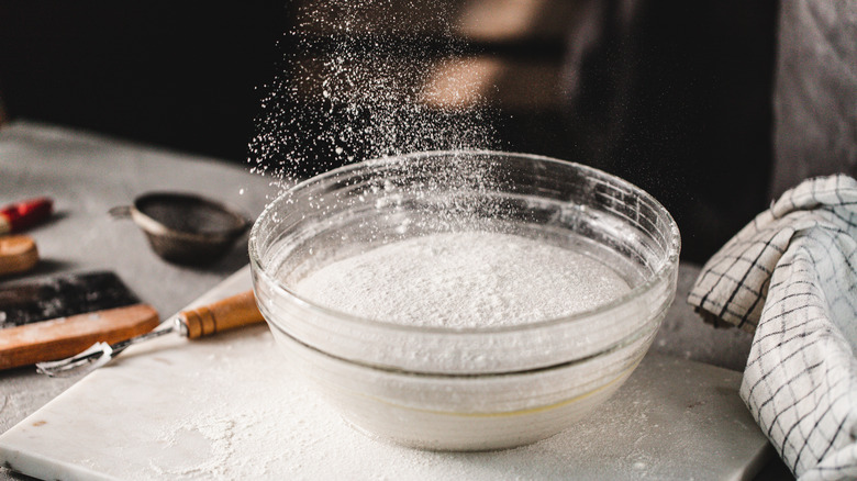 flour falling into glass bowl