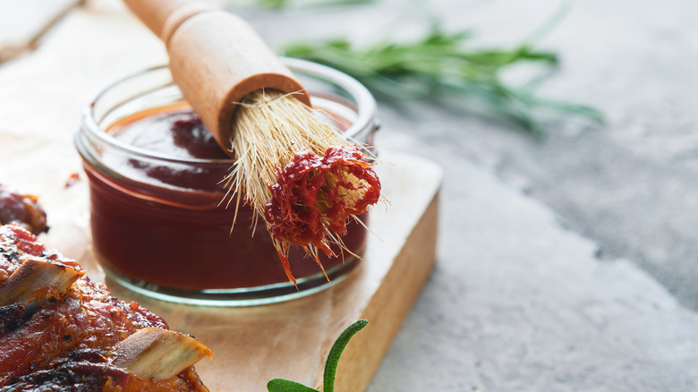 bowl of barbecue sauce and basting brush