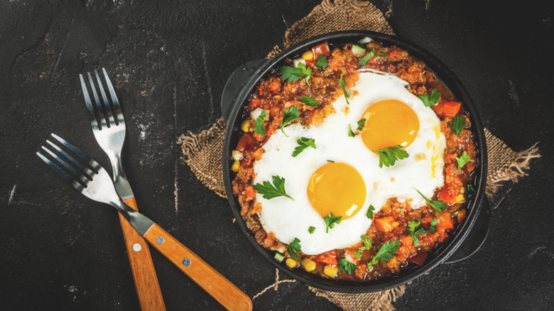 huevos rancheros with forks in cast iron pan