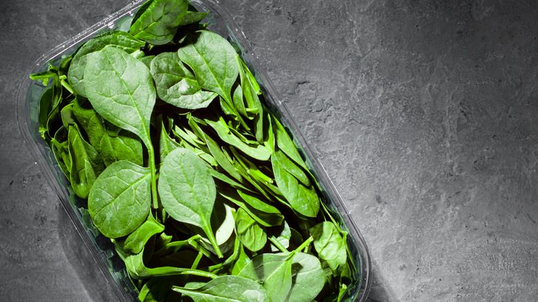 plastic box of spinach leaves