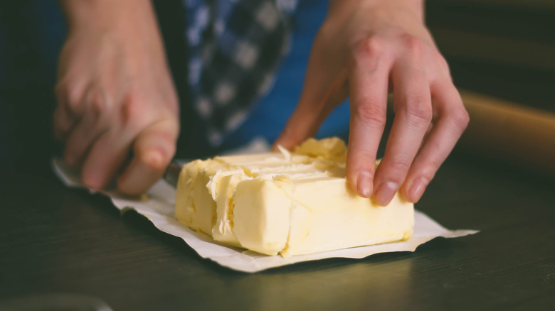 Person cutting butter with knife