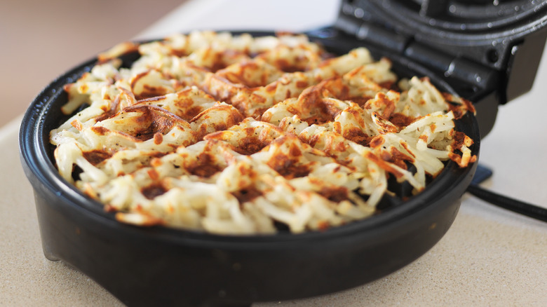 shredded potatoes in waffle iron