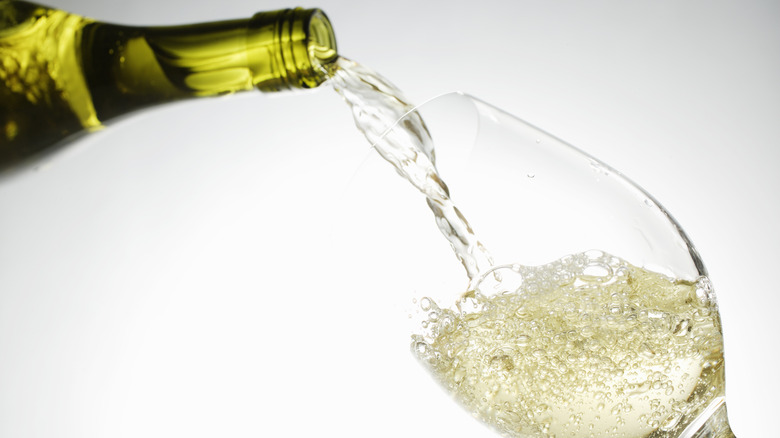 white wine being poured into a wine glass