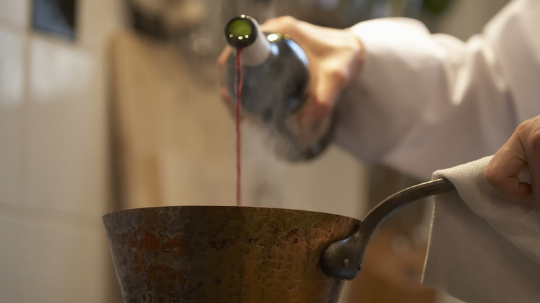 Red wine pouring into pot