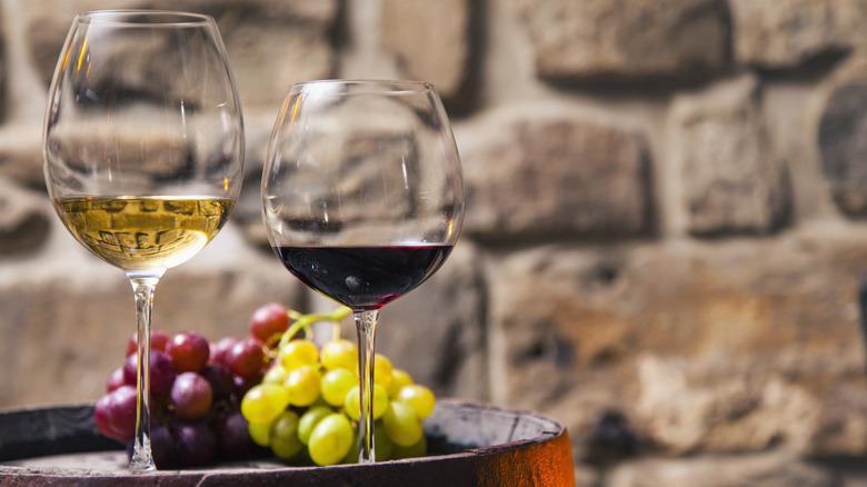 Glasses of red and white wine sitting on a barrel