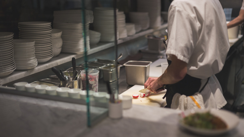 chopping radish in restaurant kitchen