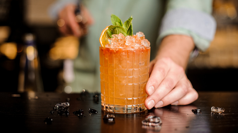 bartender serving cocktail with mint