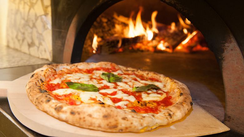 Pizza going into oven