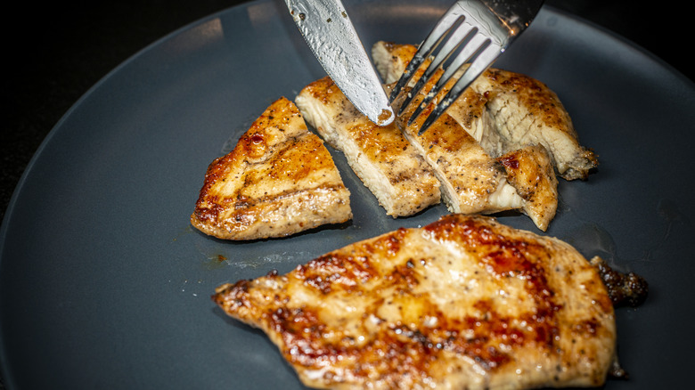 Fork and knife cutting chicken