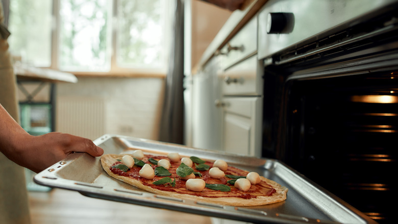 Putting pizza into oven