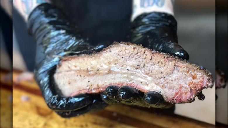 Brisket in gloved hands