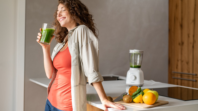 woman drinking smoothie and smiling