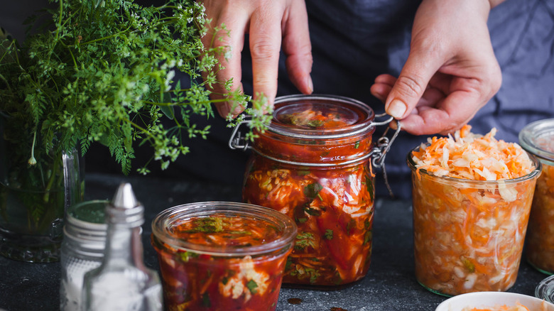 hands seal pickles in jars