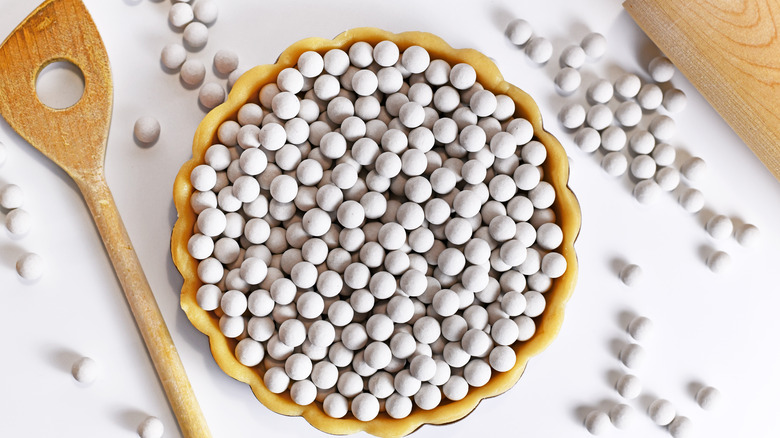 A tart shell full of pie weights for blind baking