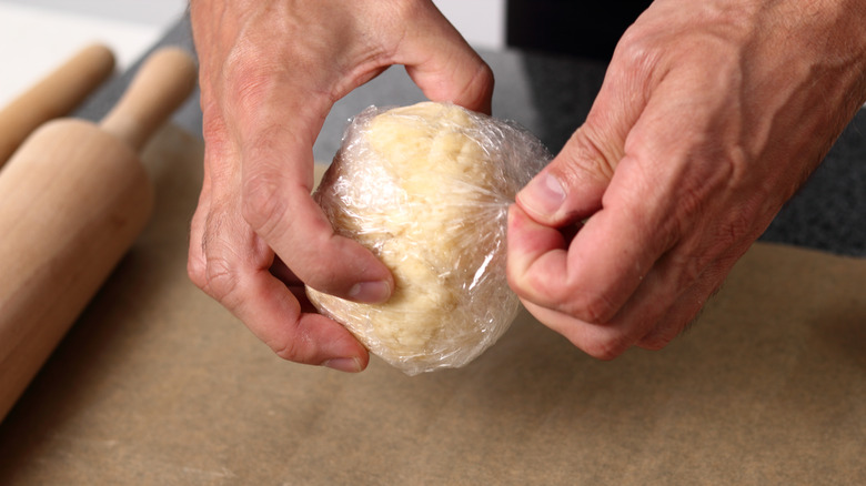 Person unwrapping chilled pastry dough