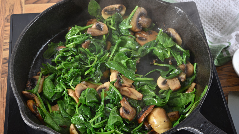 Sautéing spinach and mushrooms in cast iron pan 