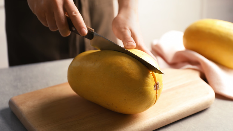 Person cutting spaghetti squash