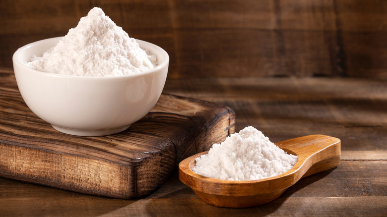 A bowl of baking soda with a wooden spoon