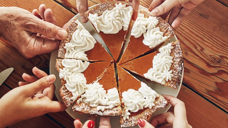 Slices of pumpkin pie with hands