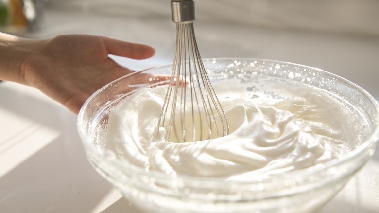 Hand whipping bowl of cream