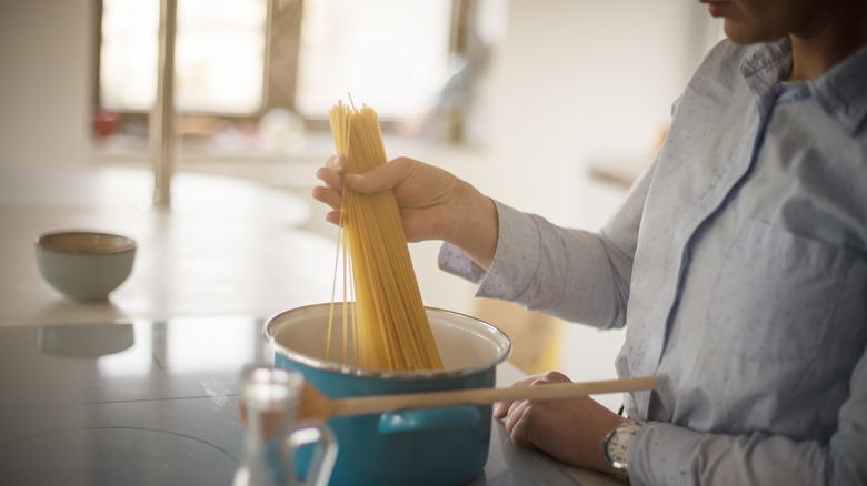 adding pasta to pot