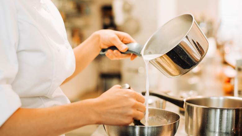 chef pouring milk from pot