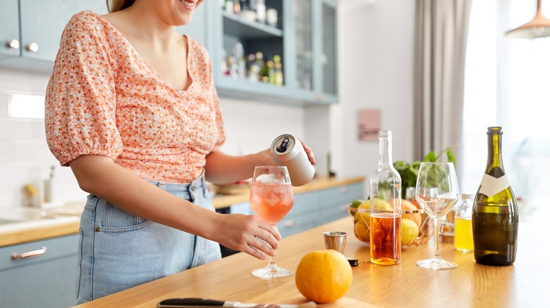 Woman making orange cocktails