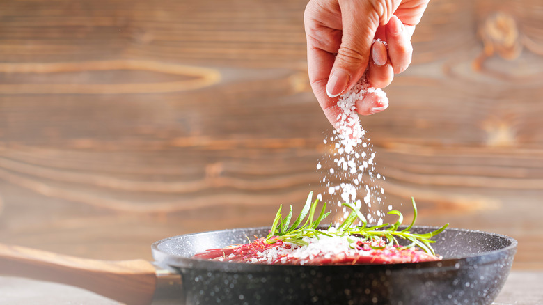 Seasoning salmon in pan