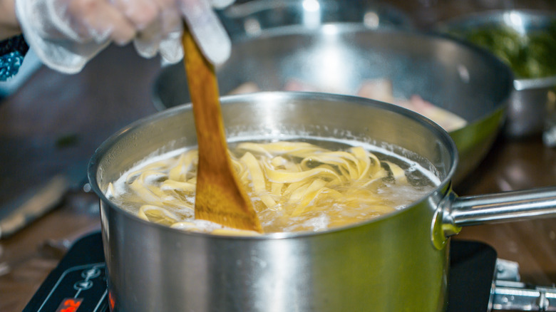 wooden spoon stirring pasta