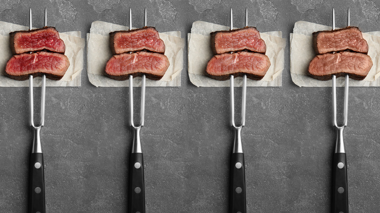 sliced steaks on carving forks