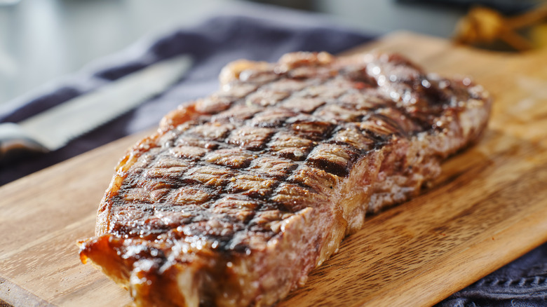 grilled steak resting on wooden board