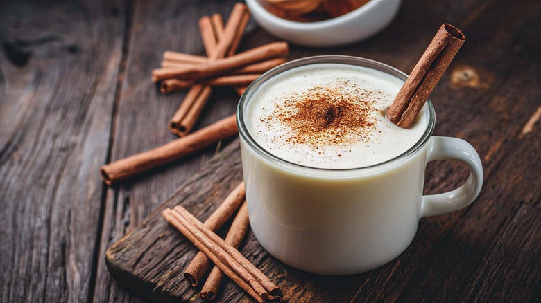 Mug of eggnog with cinnamon sticks