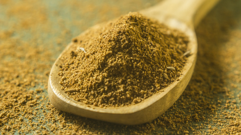 Ground cumin in a wooden spoon