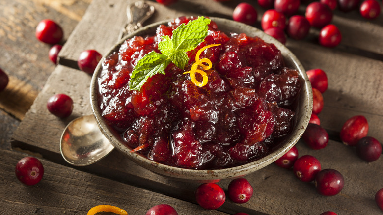 A bowl of cranberry sauce and fresh cranberries