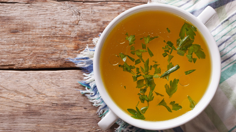 a bowl of chicken broth with herbs