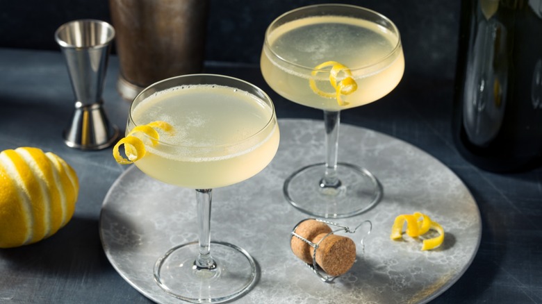 Two French 75 cocktails in coupe glasses on a tray