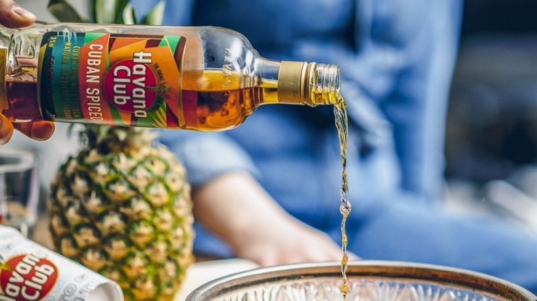 pouring booze into a bowl for fruit cocktail