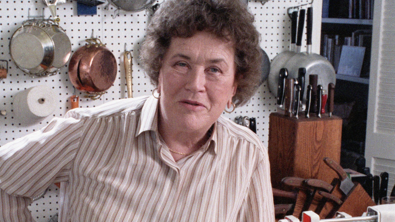 Julia Child posing in her kitchen