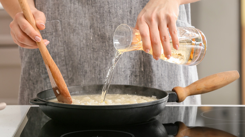 woman pouring wine into pan 