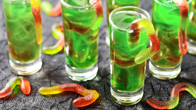 brightly colored liquor with gummy worm candy garnish