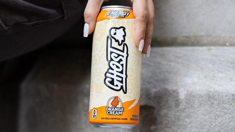 Holding orange cream Ghost Energy can