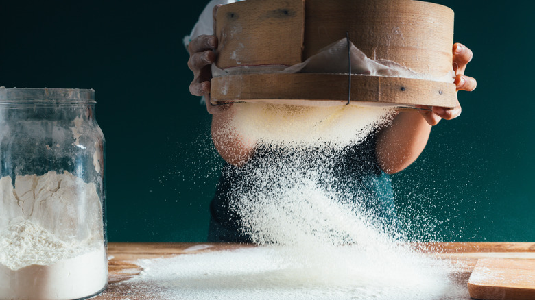 baker sifting flour