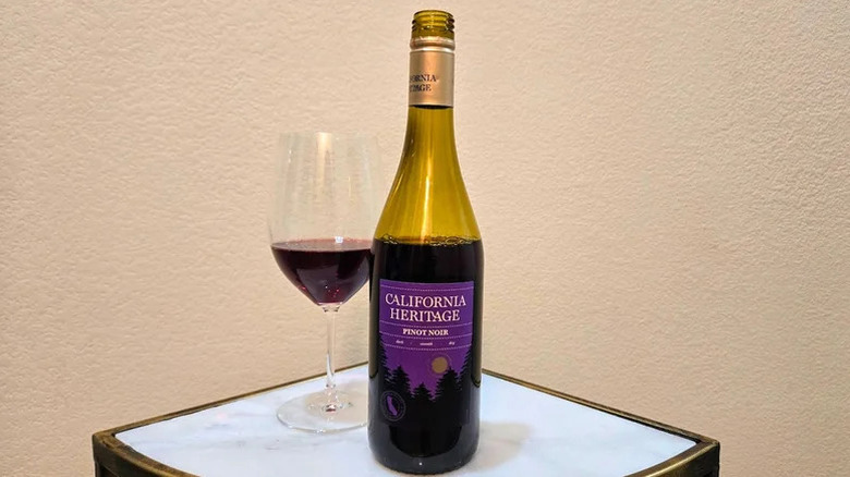 an opened bottle of California Heritage pinot noir next to a glass with wine