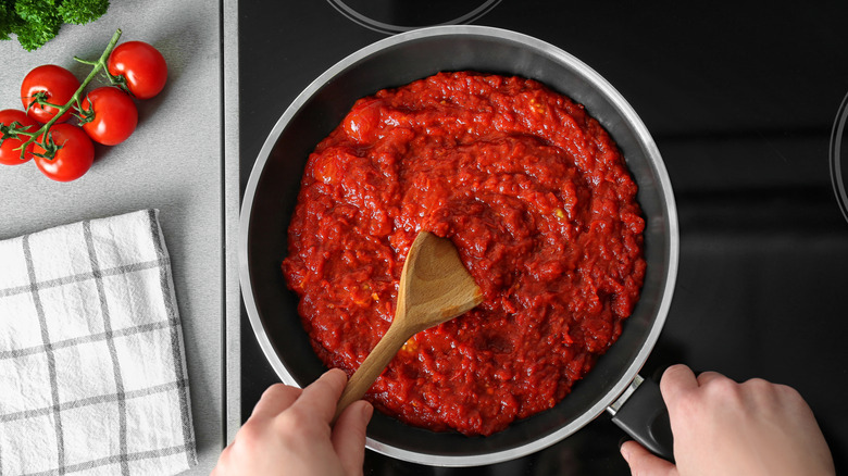 hands making marinara sauce