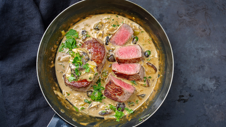 steak in a mushroom cream sauce in a skillet