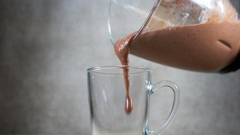 pouring milkshake into glass