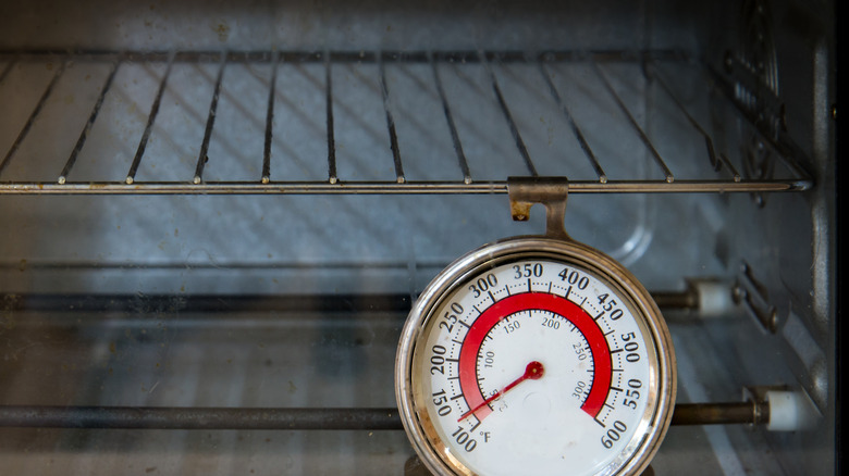 oven thermometer hanging from an oven rack