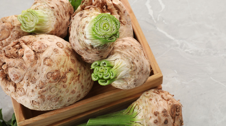 fresh raw celery roots in a wooden crate