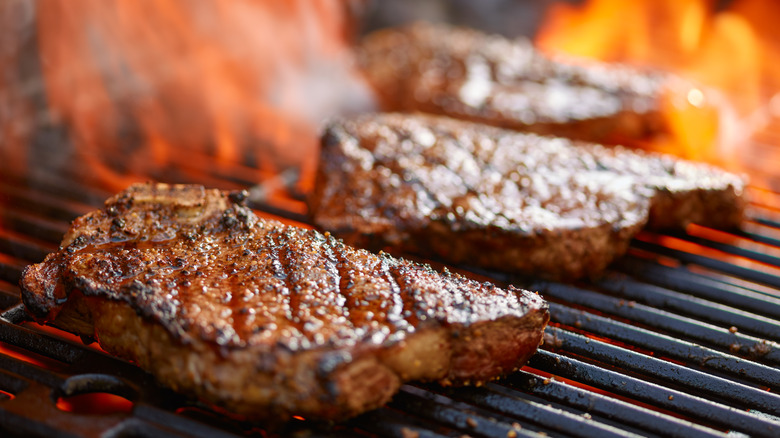 Steaks on flaming grill